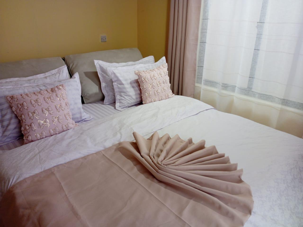 Second bedroom with pale linens and morning light